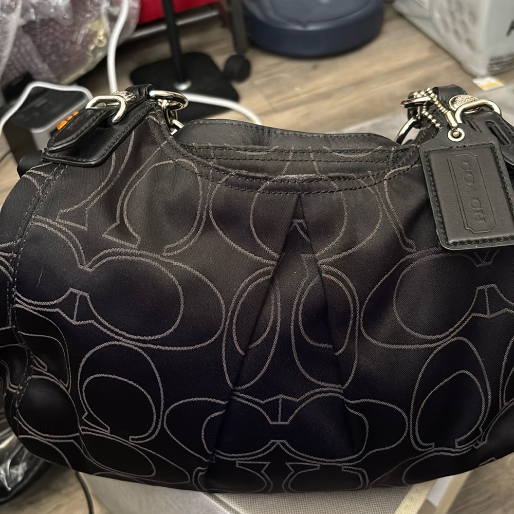 Coach black shoulder bag with metal accents.